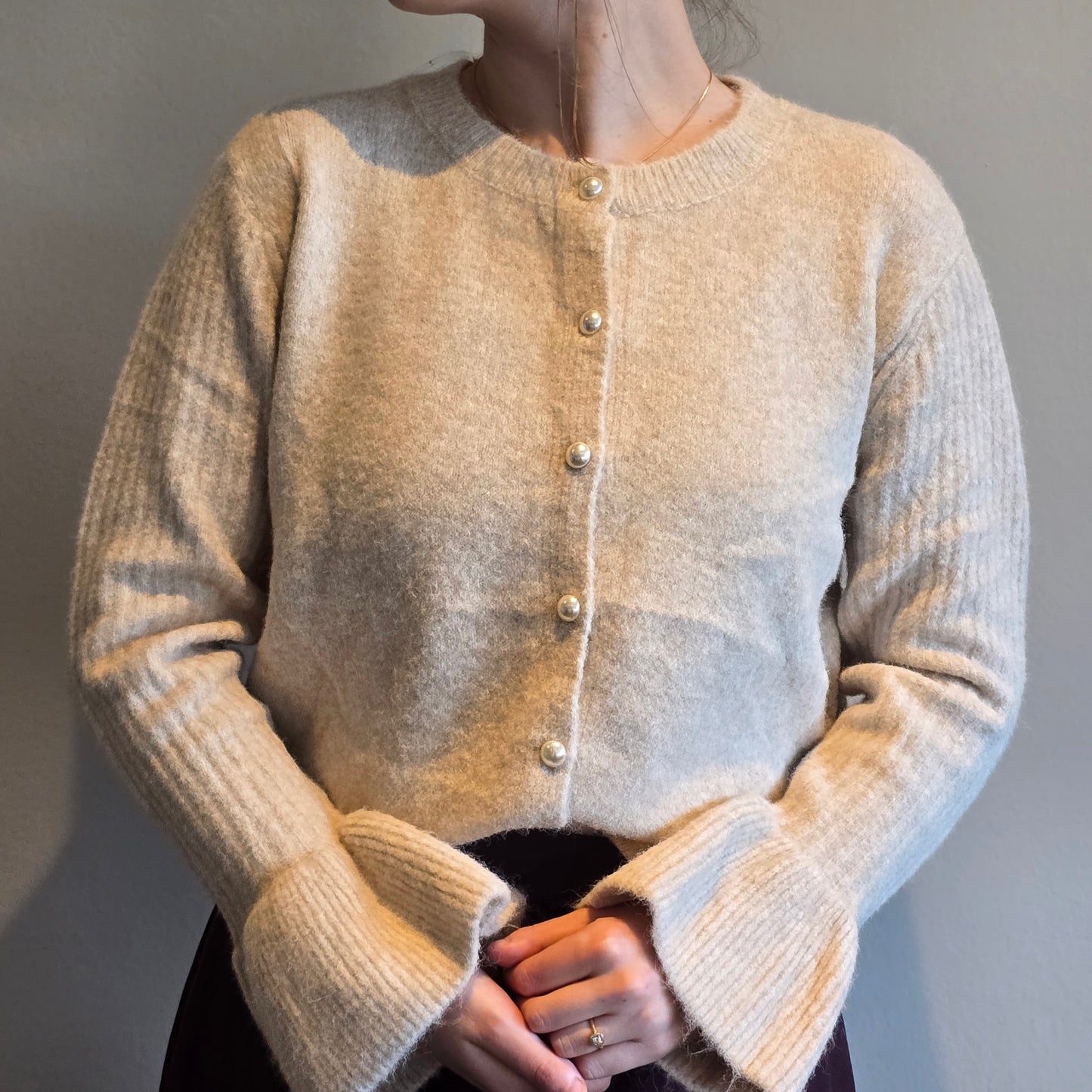 Crème trui met pareltjesknoop