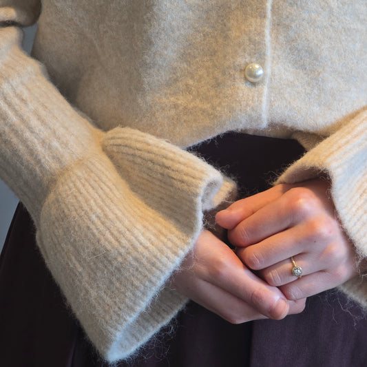 Crème trui met pareltjesknoop